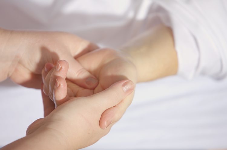 Ein Akupunkturpunkt in der Handfläche wird massiert.